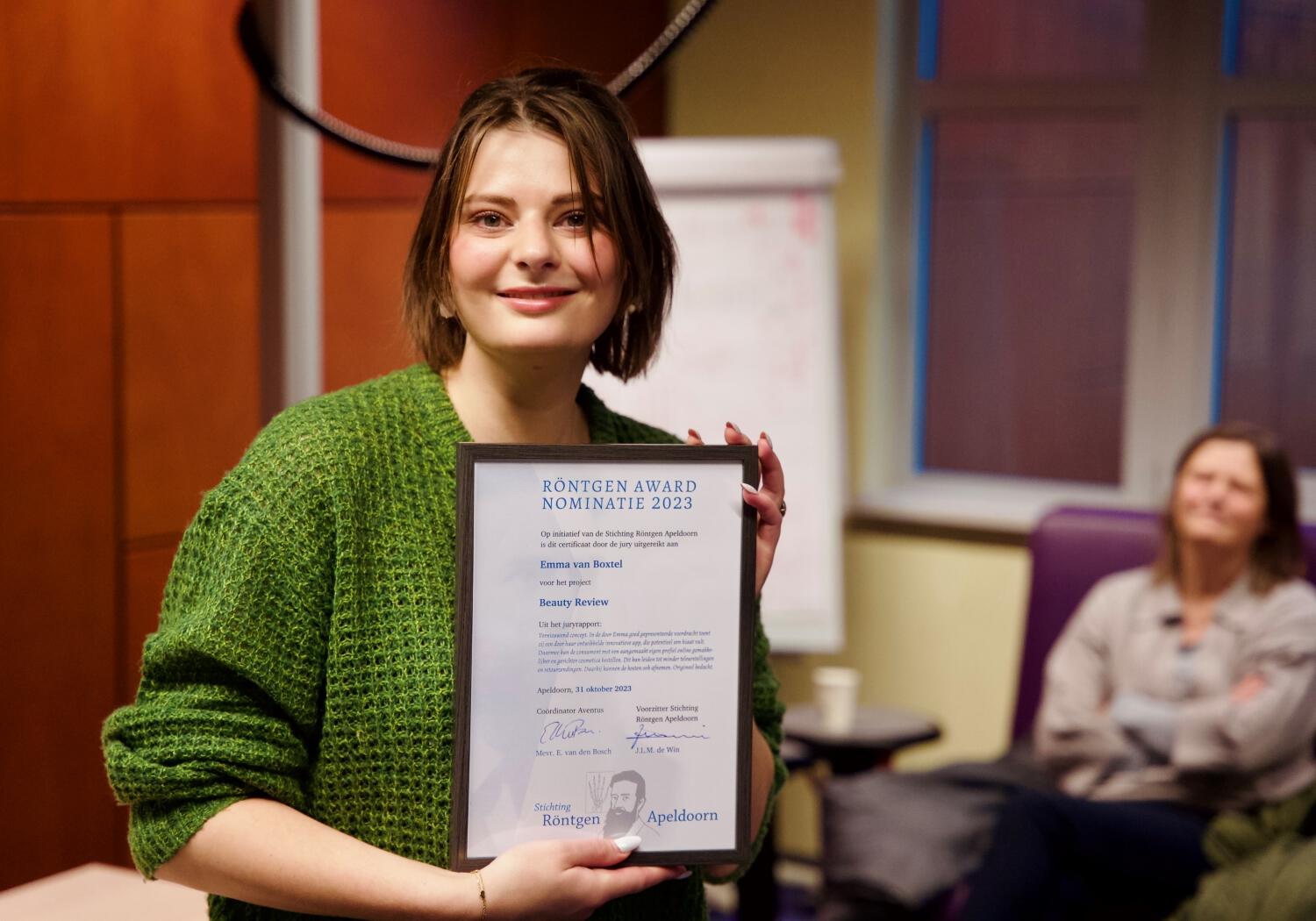 Winnares Röntgen Award laat trots haar oorkonde zien