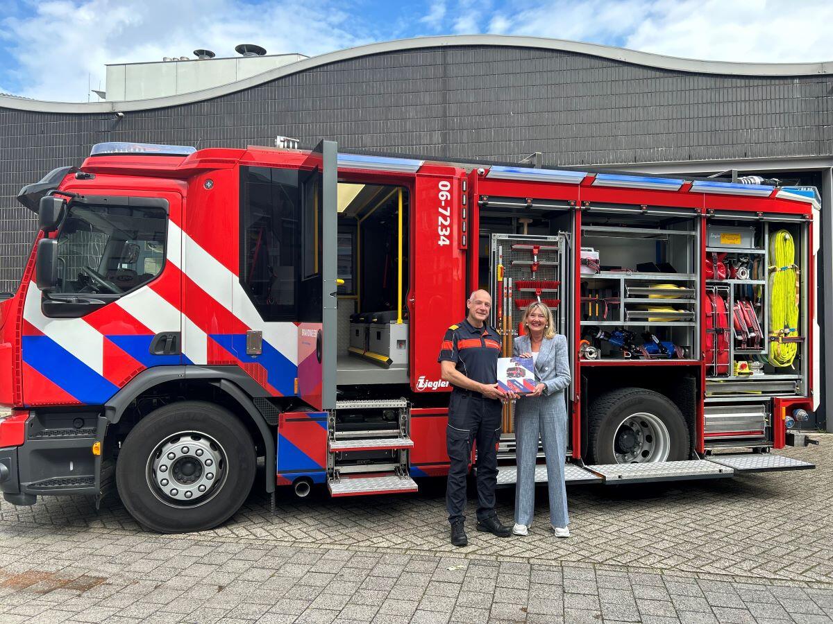 Ellen Marks poseert met een brandweerman voor een bluswagen