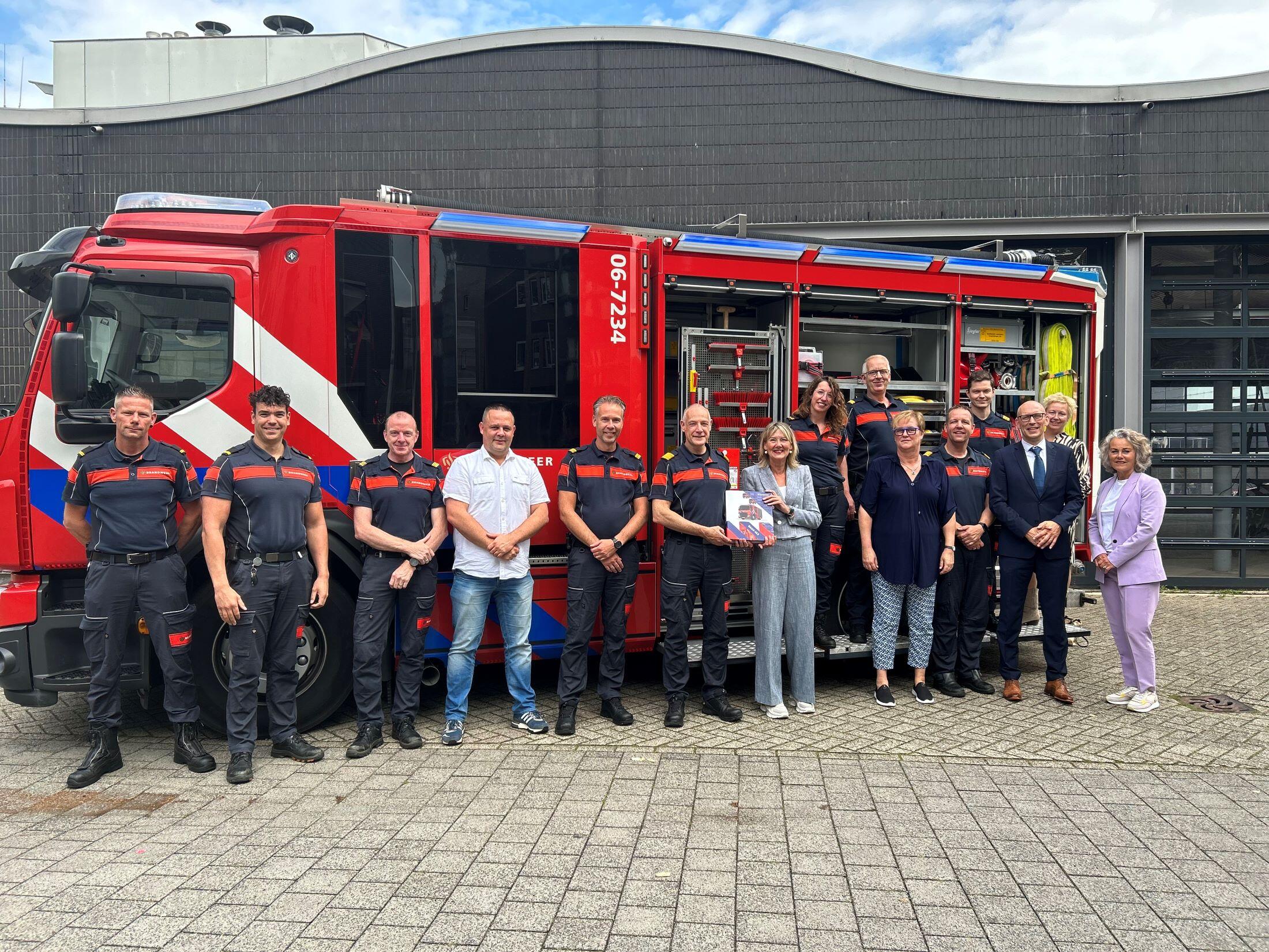 Ellen Marks poseert met een groep brandweermannen voor een bluswagen