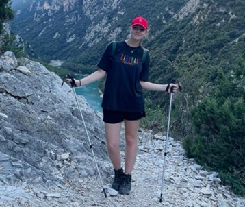 Een sportieve jongedame in hike outfit in de bergen