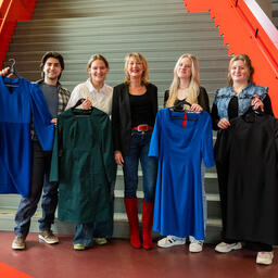 Vier tweedejaarsstudenten van de opleiding Fashion tailor poseren met hun kledingstuk met Ellen Marks